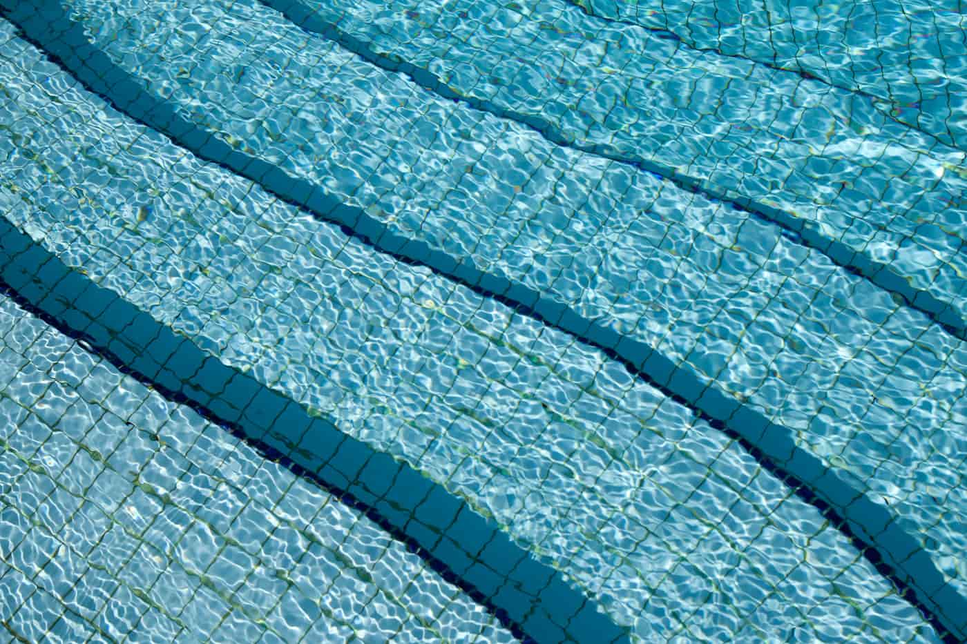 Chlorinated water surface reflecting hard blue light